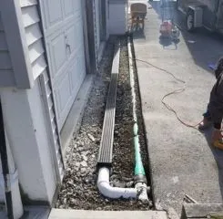 Channel drain with piping installed in driveway